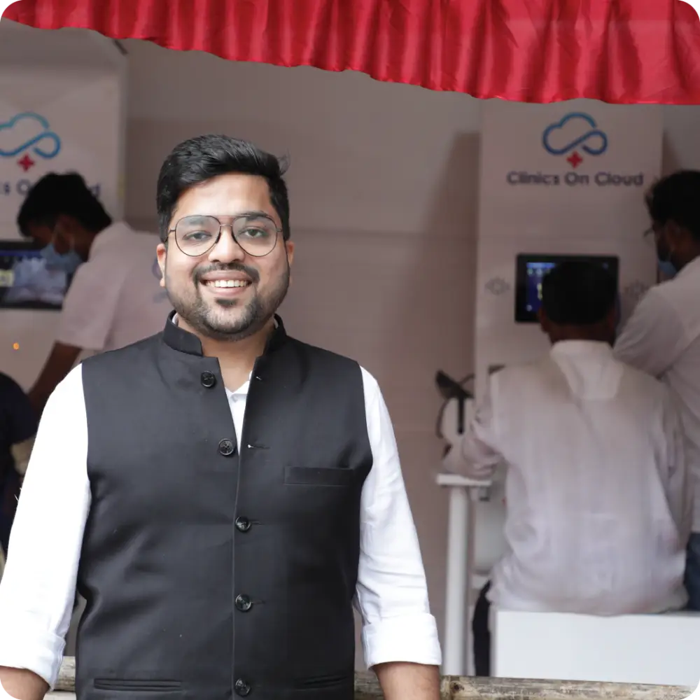 Abhay Agarwal beside a Clinics On Cloud backdrop
