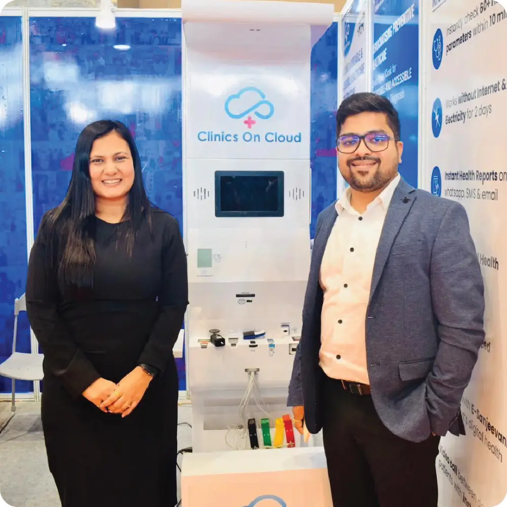 Two colleagues beside a Health ATM on a Clinics On Cloud stand