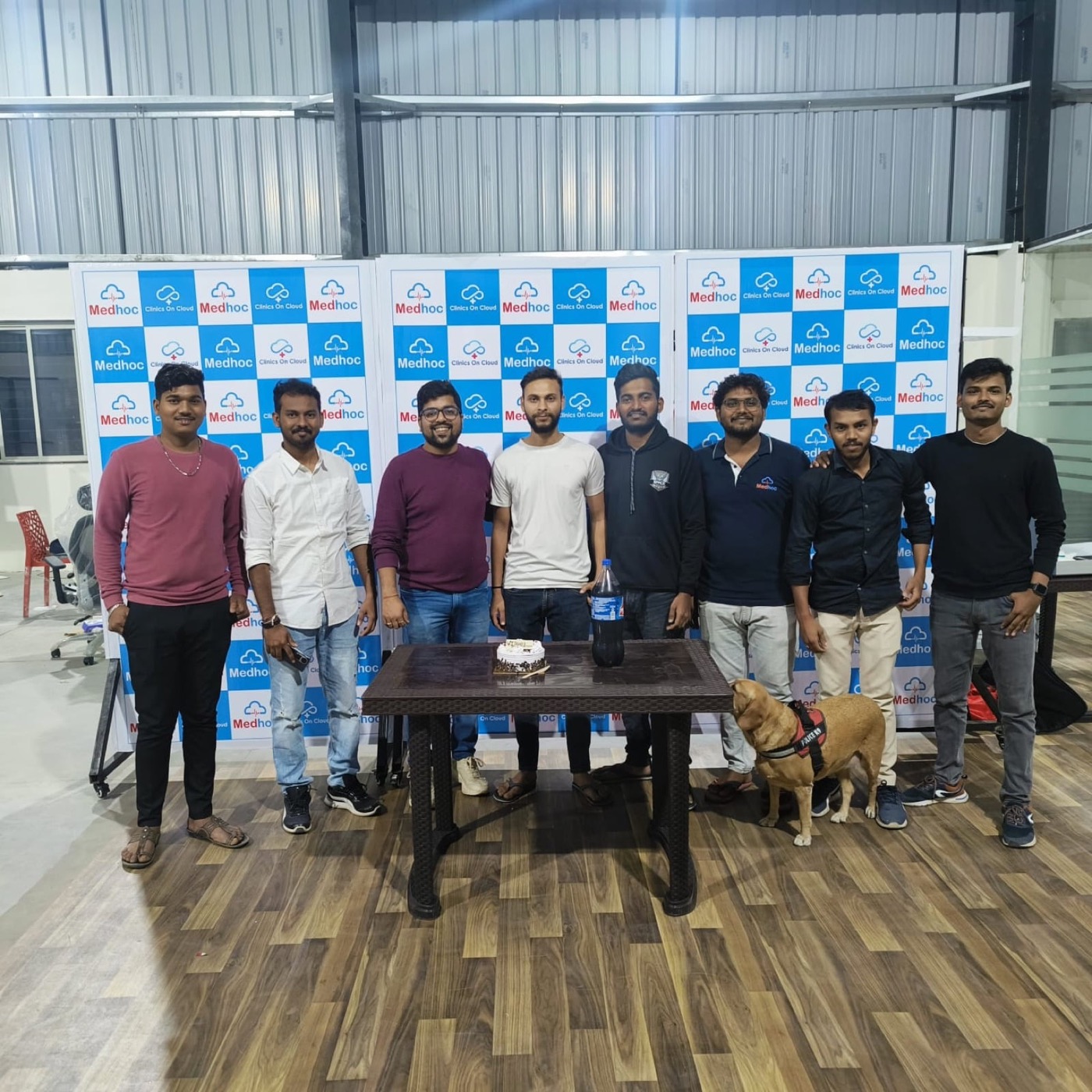 A team photograph at a branded backdrop